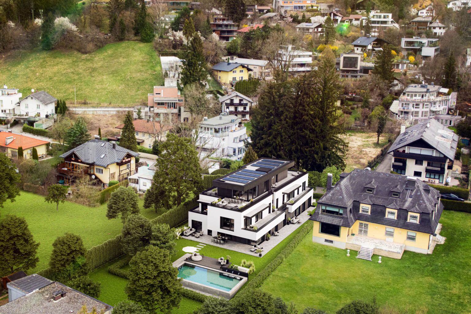 3D-Architekturvisualisierung eines modernen Wohngebäudes mit Pool, Lounge-Zonen und Photovoltaikanlage in Salzburg